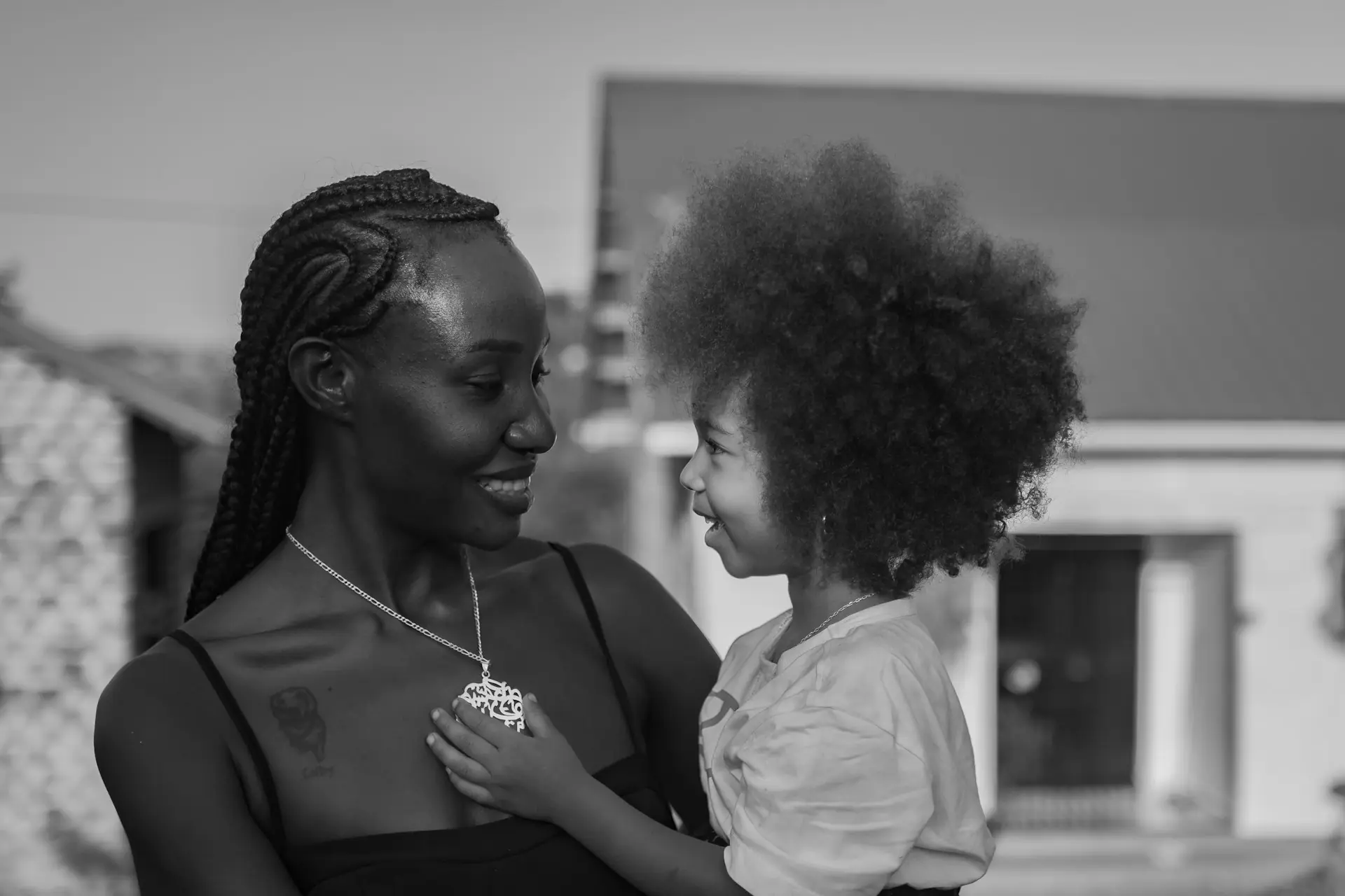 A mother holding her child close, both smiling.
