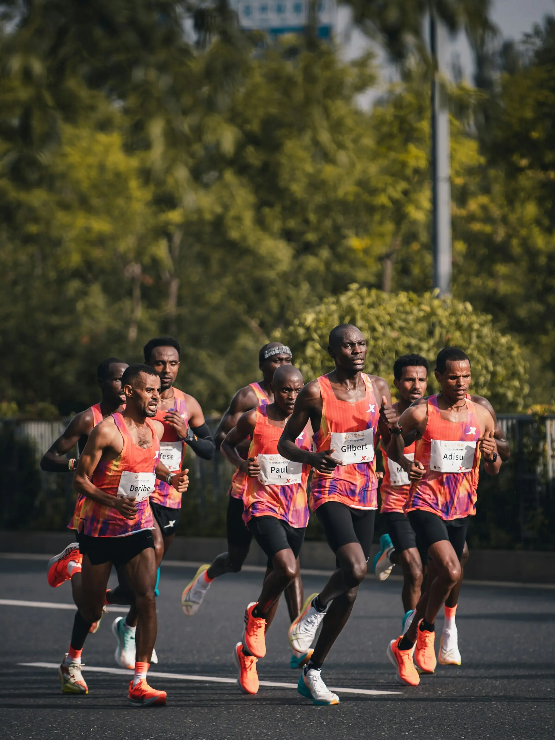 A lead pack of marathon runners in bright kit, deep into a race.